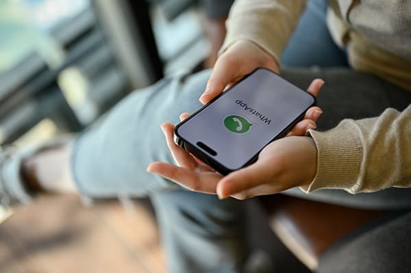 Una persona sostiene su teléfono con WhatsApp abierto.